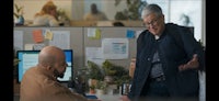 two men in an office talking to each other