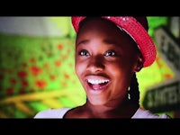 a young girl wearing a red hat and smiling