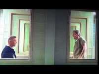 two men in a jail cell looking at each other