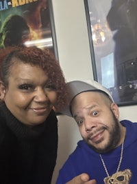 a man and woman posing for a photo in front of a movie poster