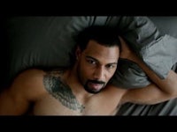 a man with tattoos laying in bed