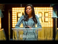 a woman is standing at a podium at an event